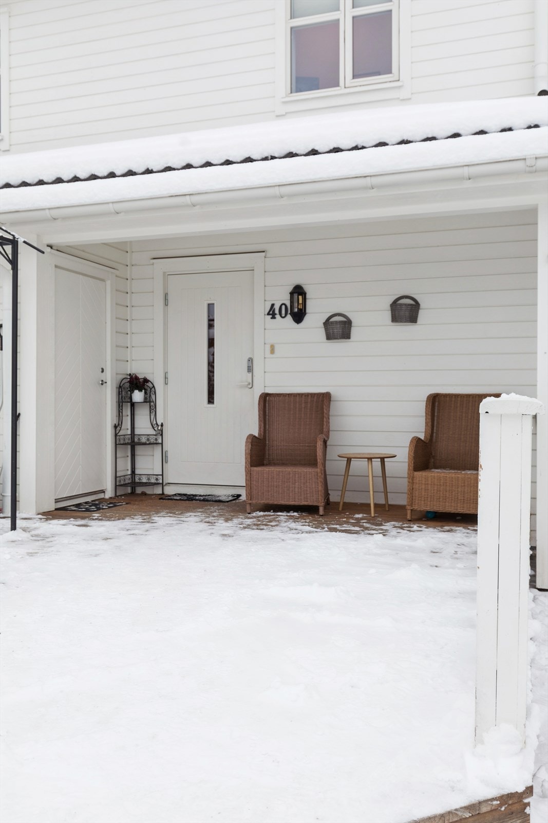 Overbygd inngangsparti med plass til en liten sittegruppe. Galleribilde