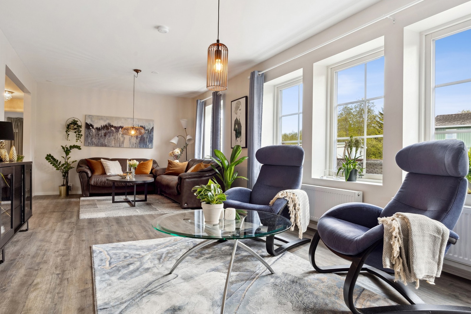 Store vinduer sørger for rikelig med naturlig lys til stuen. Galleribilde