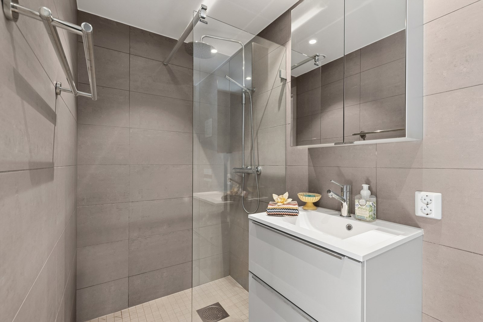 Privat baderom med dusj, vegghengt toalett og praktisk oppbevaring. Galleribilde