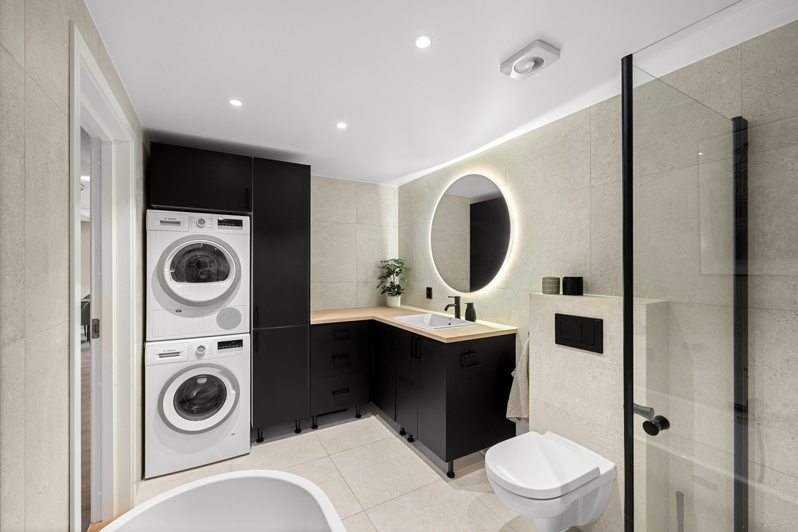 Badet er er innredet med dusjhjørne med glassdører, frittstående badekar, vegghengt toalett og baderomsinnredning med god lagringsplass. Galleribilde