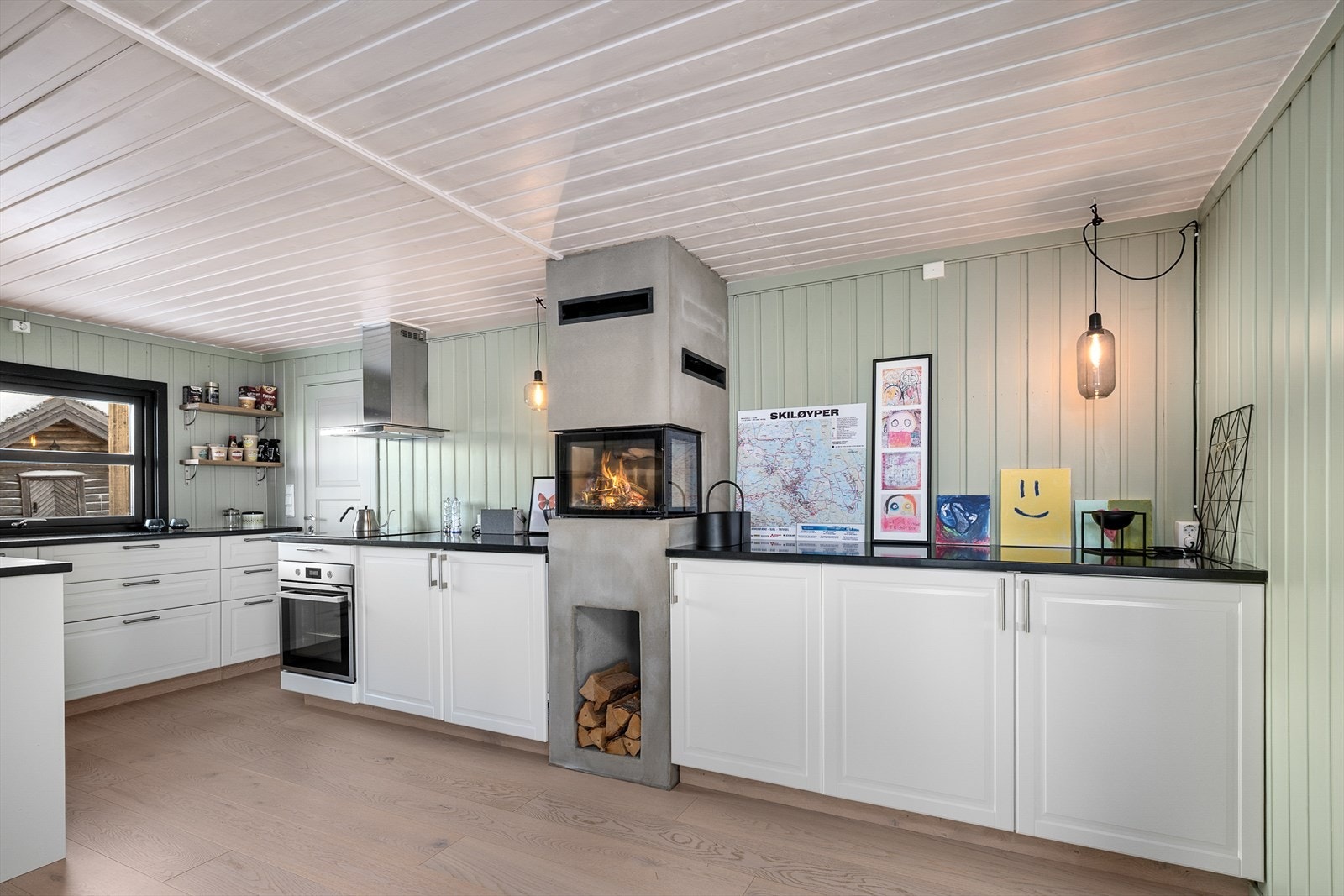 Kjøkkenet er lyst og funksjonelt, med peis som er bygget bygget inn i kjøkkeninnredningen. Galleribilde