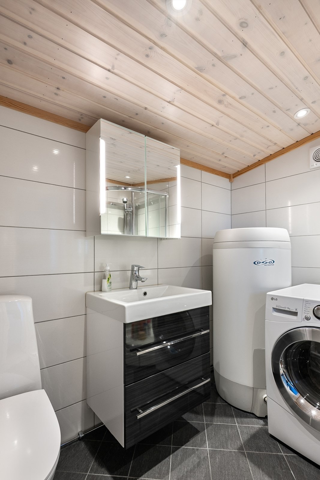 Baderomsinnredning med servant og speilskap med integrert belysning. Galleribilde