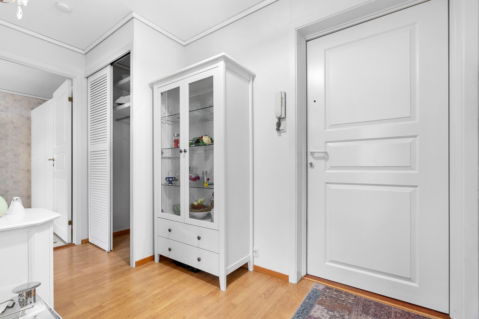 Du ønskes velkommen inn i leiligheten via en lys og innbydende gang, som tilbyr rikelig med oppbevaringsplass for både klær og sko. Galleribilde