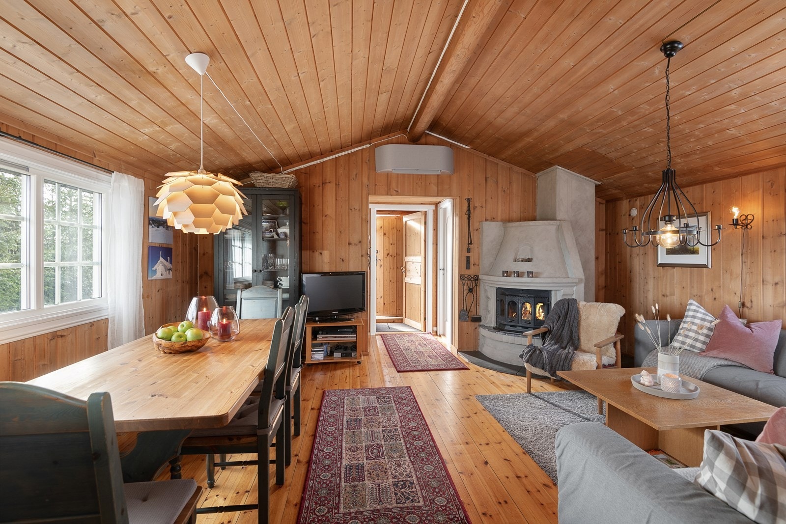 I ene hjørnet i av oppholdsrommet er det plassert en peis med innsats. Denne gir god varme og skaper hyggelig stemning. I tillegg varmes hytta opp med elektrisk fyring. Galleribilde