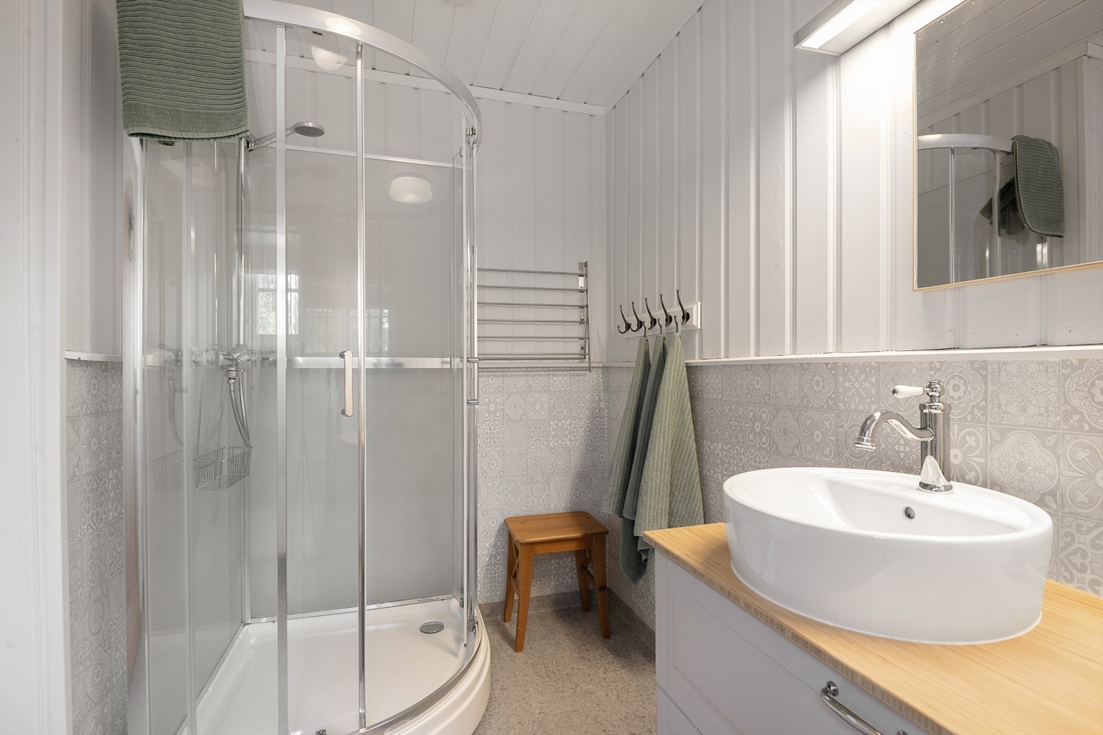 Badet har malt panel på veggene med brysning og belegg på gulv. Galleribilde