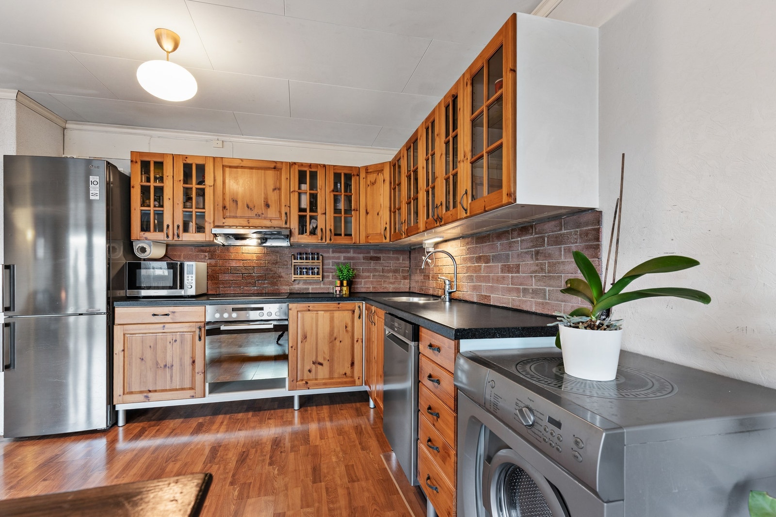 Kjøkkenet er med profilerte fronter og laminat benkeplate med nedfelt vaskekum. Av integrerte hvitevarer er det platetopp, stekeovn og opplegg for vaskemaskin. Galleribilde