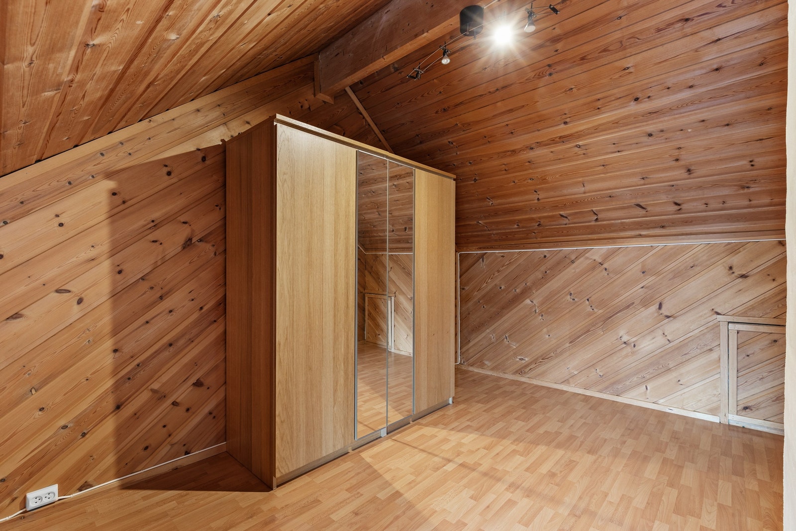 Rommet kan også benyttes som soverom om ønskelig. Det er også rikelig med oppbevaring i et kneloft, som går langs veggen med luken. Galleribilde