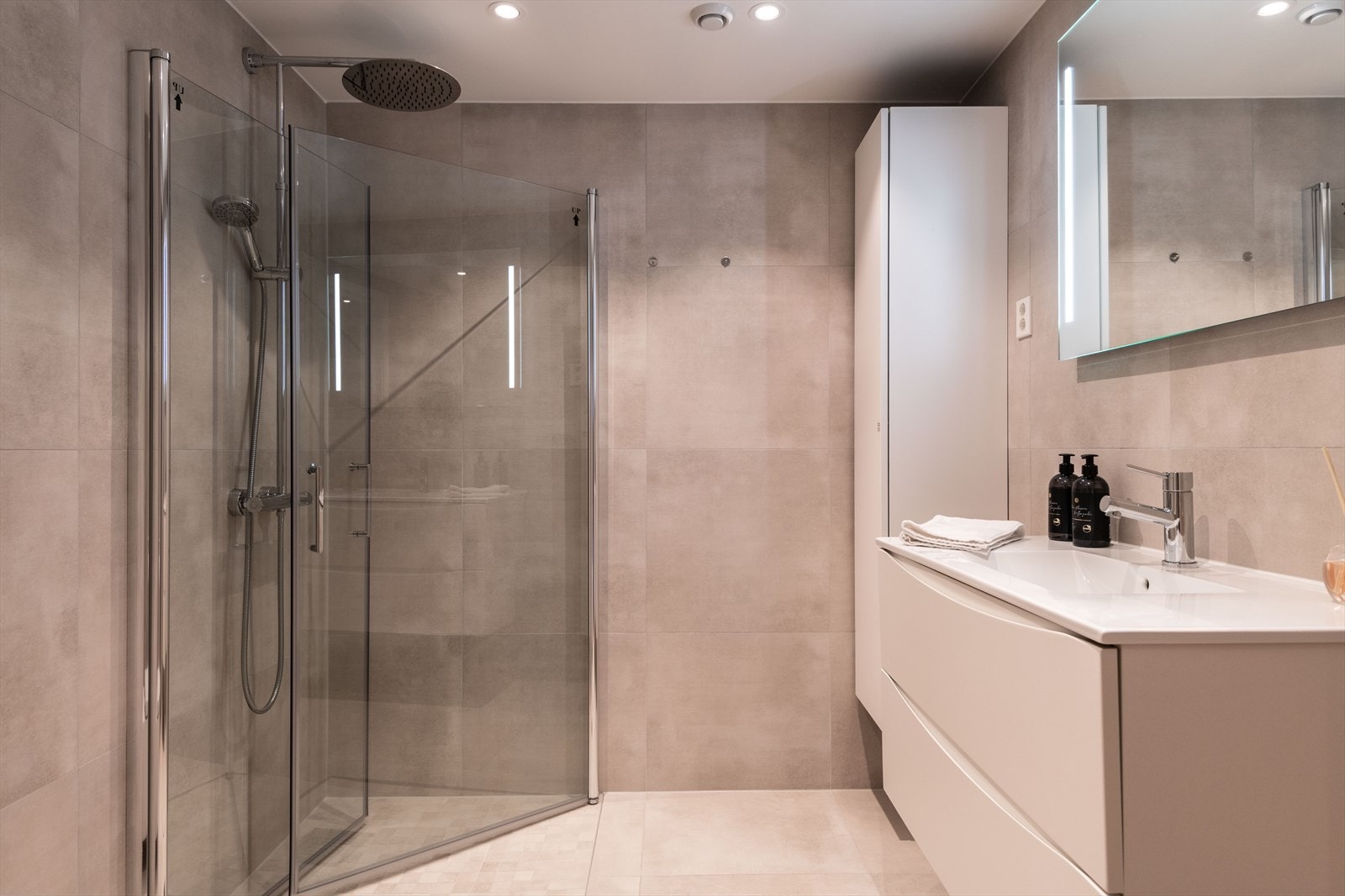 Dusj med glassdører og vegghengt toalett gir et moderne uttrykk. Galleribilde