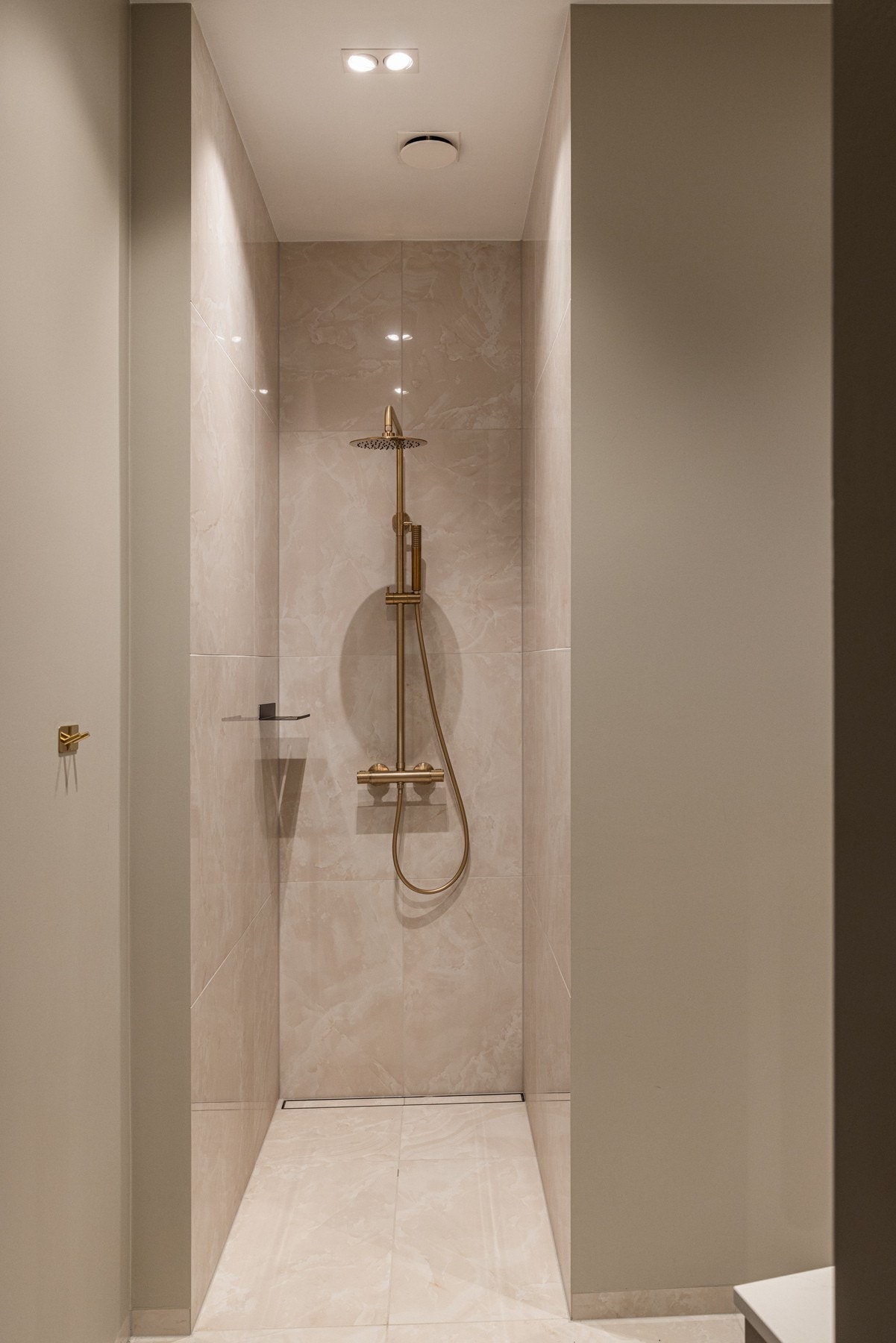 Åpen dusjnisje med regnfallsdusj. Tile insert sluk i samme flis som gulvet. Galleribilde