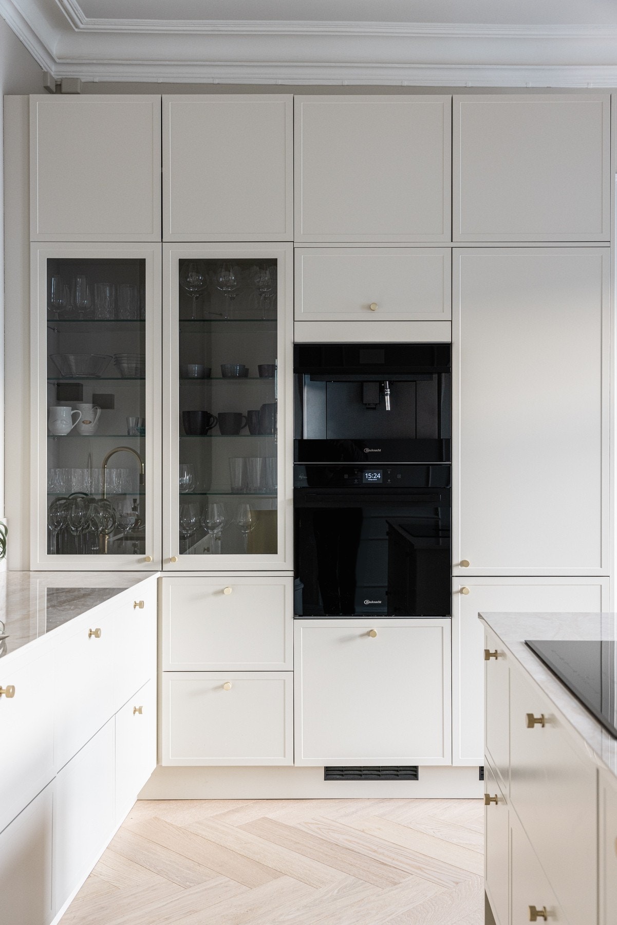 Innebygde vitrineskap i kjøkkeninnredning med eksklusivt, sotet glass. Galleribilde