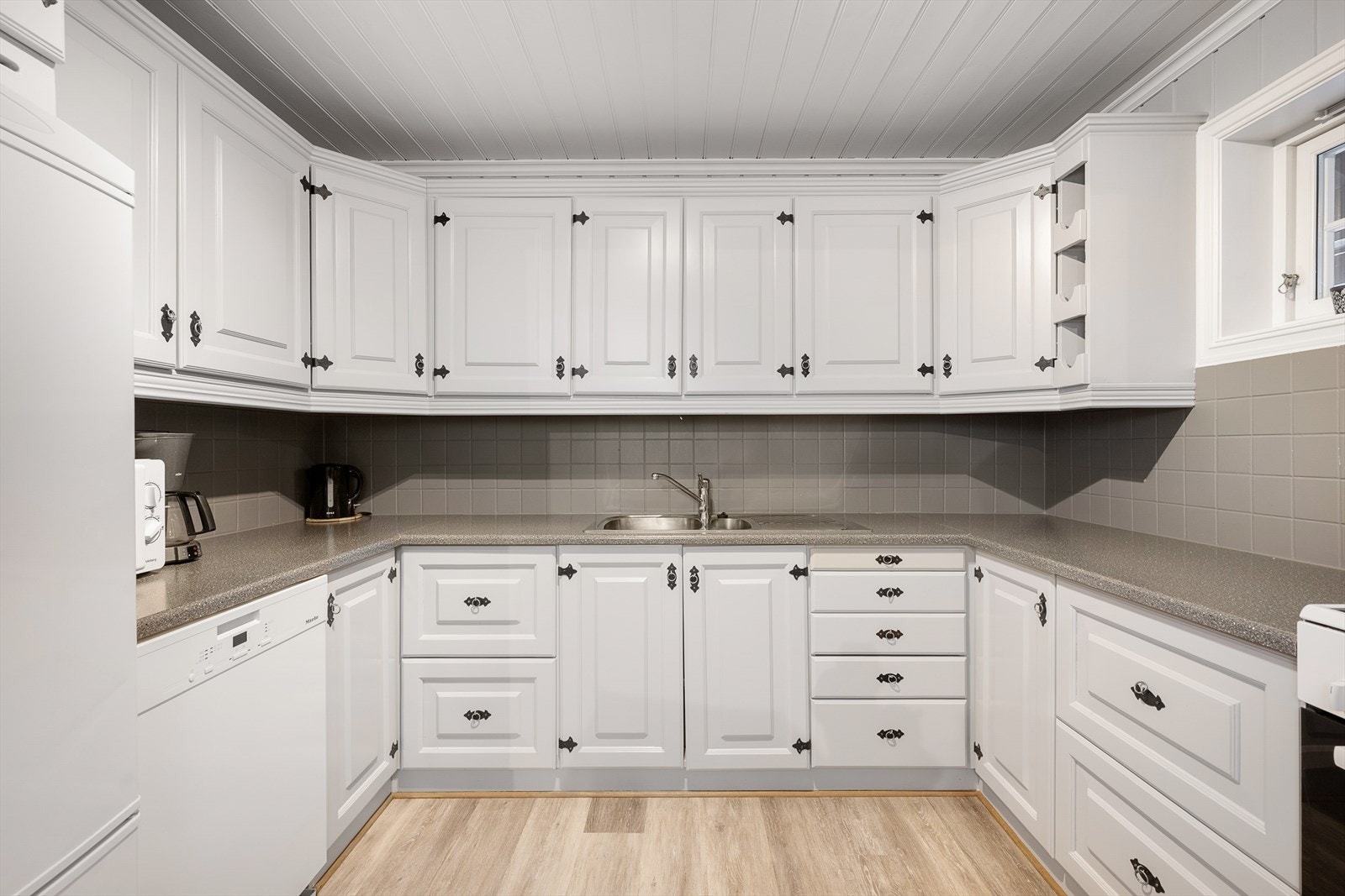 Lyst og trivelig kjøkken har en praktisk U-form med rikelig skap- og benkeplass. Galleribilde