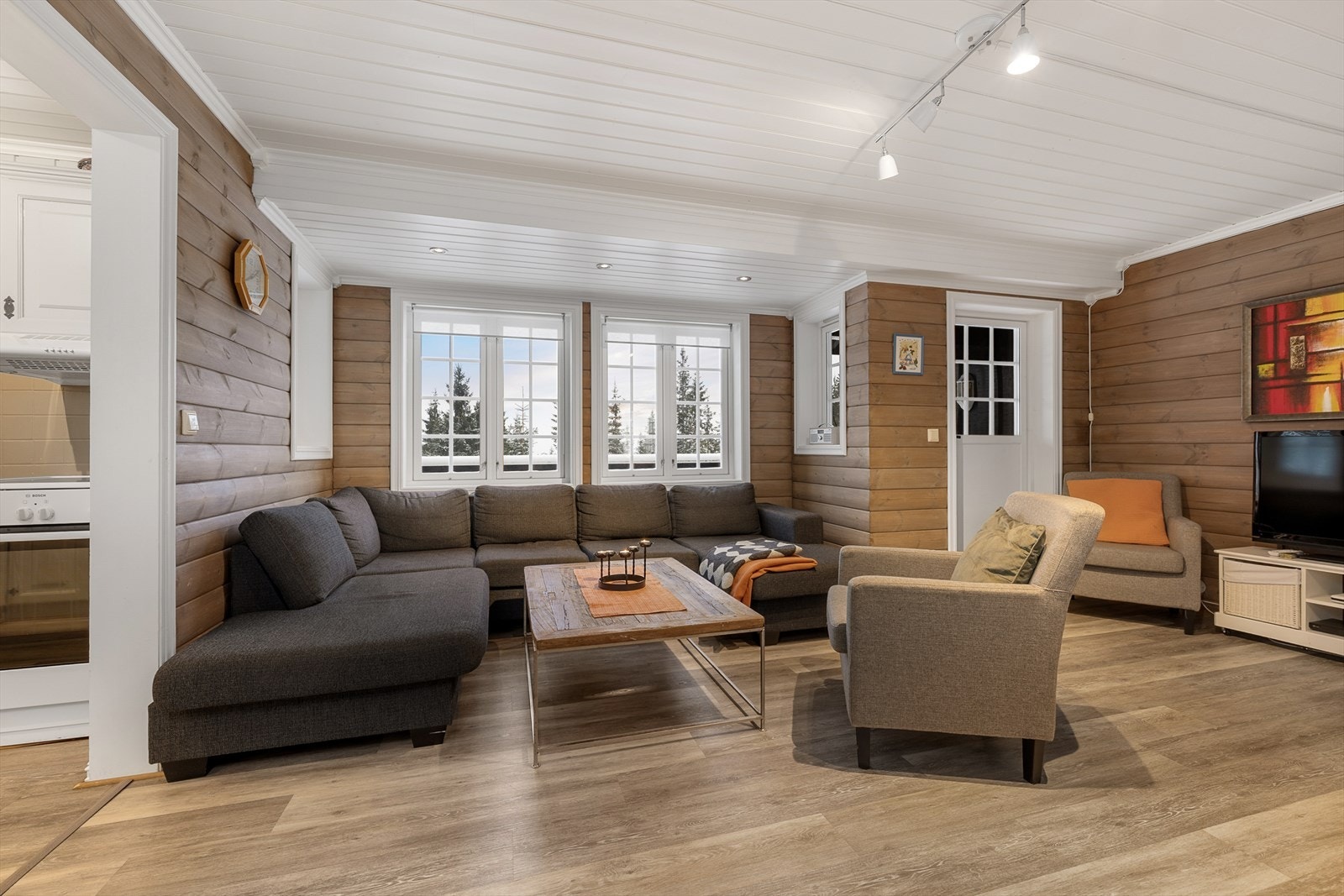 Stuen er hyttas naturlige samlingspunkt, med god plass til en stor sofagruppe. Galleribilde