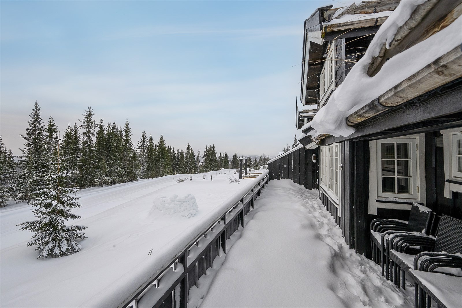Den store terrassen strekker seg langs hele hyttas fasade. Galleribilde