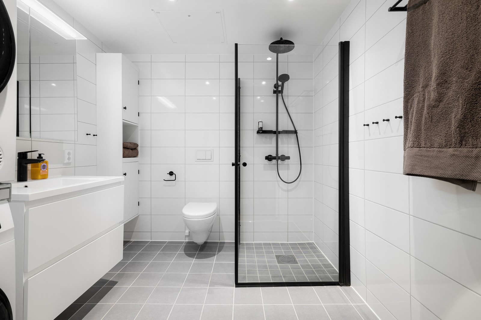 Pent flislagt baderom med hvite og grå fliser med TG1. Galleribilde