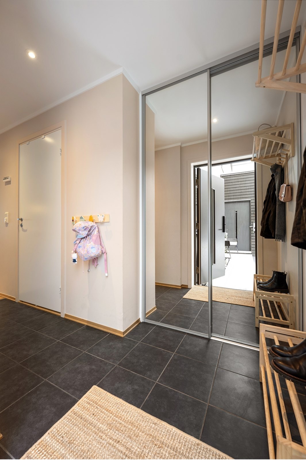 Det første som møter deg er en innbydende entré med gode oppbevaringsmuligheter for sko og yttertøy i en praktisk skyvedørsgarderobe med speilfronter. Galleribilde