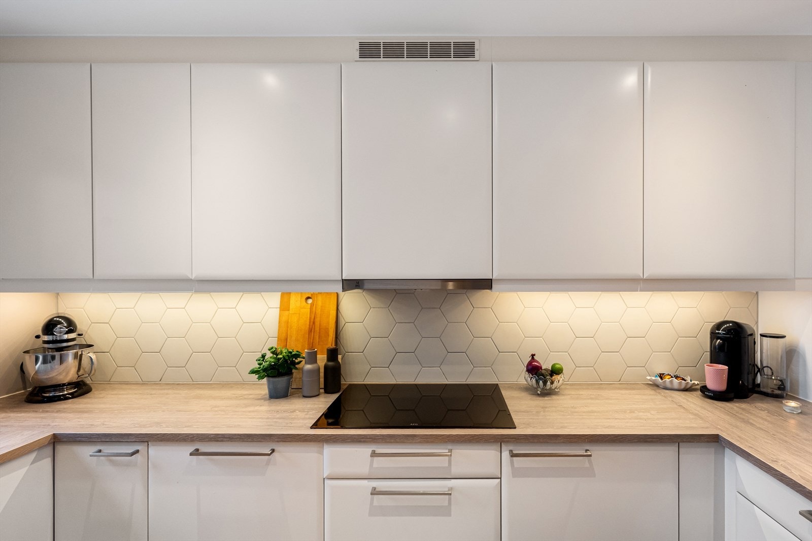 Kjøkkenet er utstyrt med integrerte hvitevarer og har rikelig med skap- og benkeplass, noe som gir gode arbeidsforhold og gjør matlagingen til en glede. Galleribilde