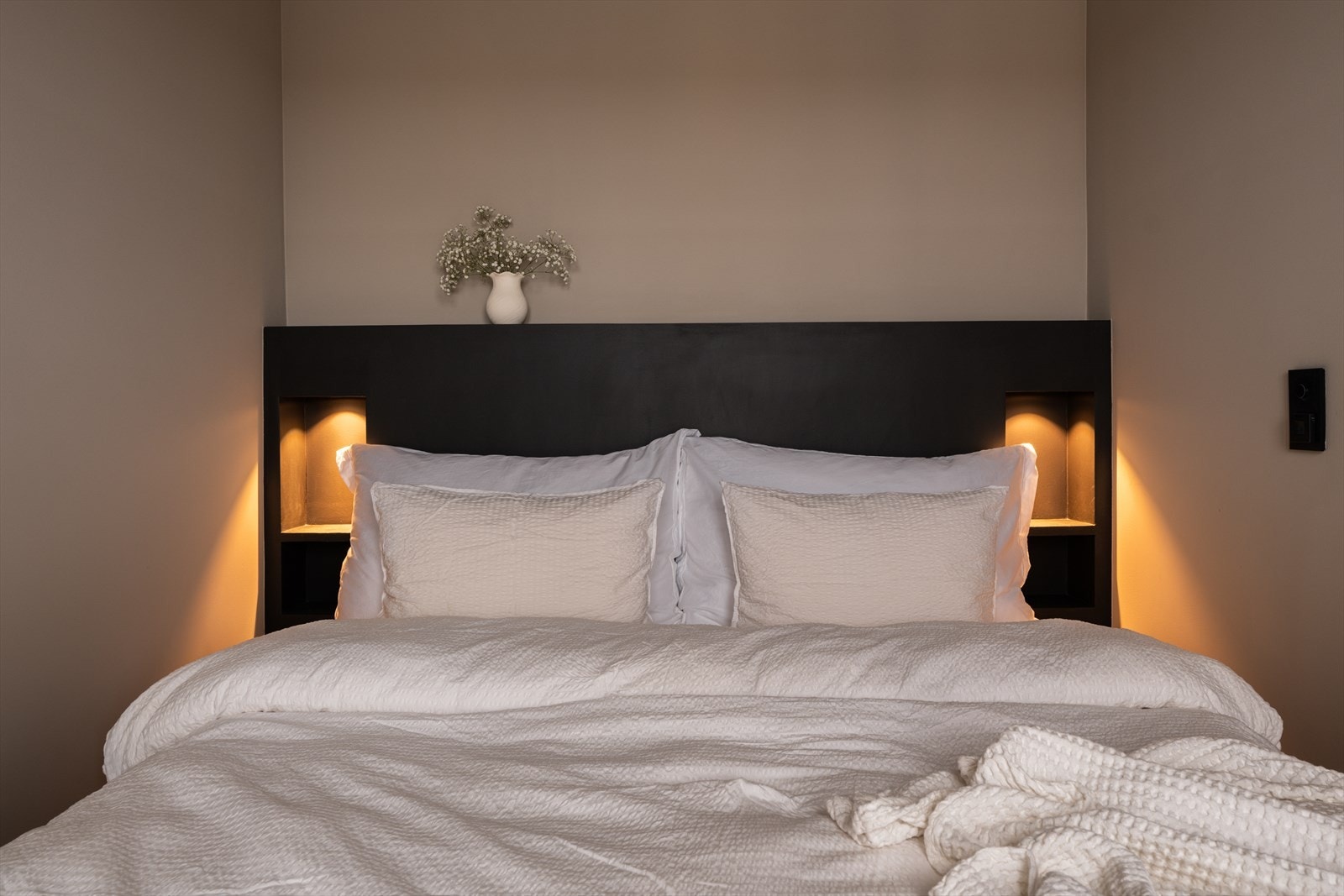 Sengegavlen har integrerte nattbord og praktiske lademuligheter. Galleribilde