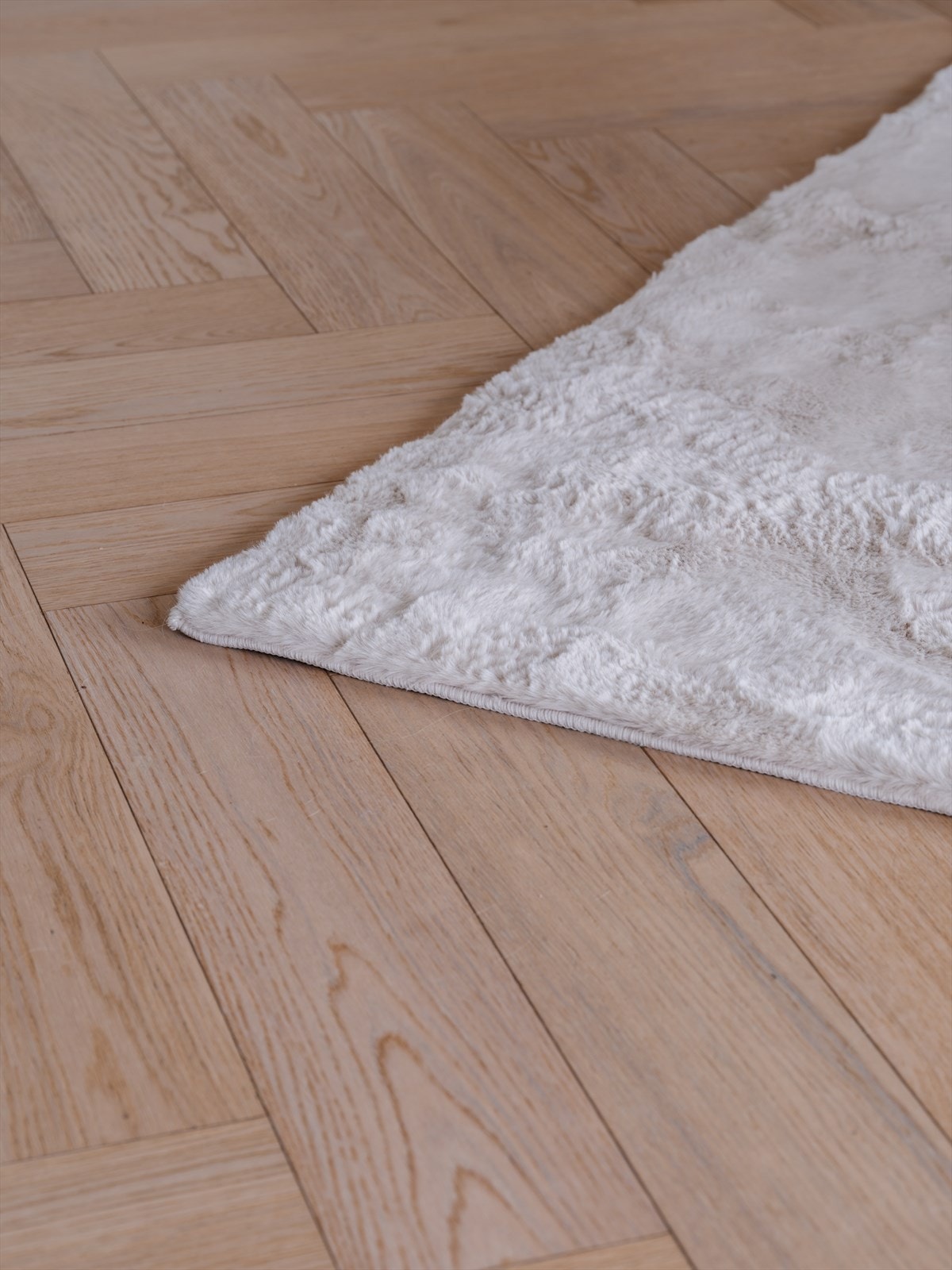 Gjennomgående eikeparkett i fiskebensmønster med varmefolie binder rommene elegant sammen. Galleribilde