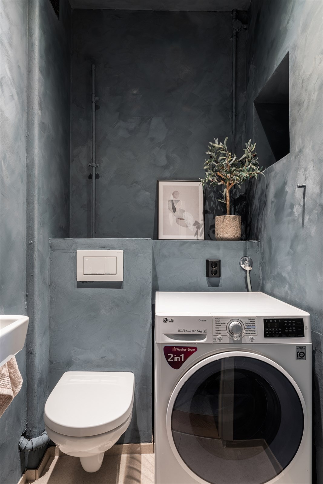 Et stort pluss er det separate vaskerommet med ekstra toalett. Rommet er praktisk innredet med flislagt gulv, servant og opplegg for vaskemaskin. Galleribilde