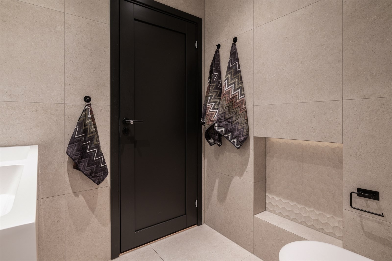 Vegghengt toalett og sorte detaljer gir et ryddig og moderne uttrykk. Galleribilde