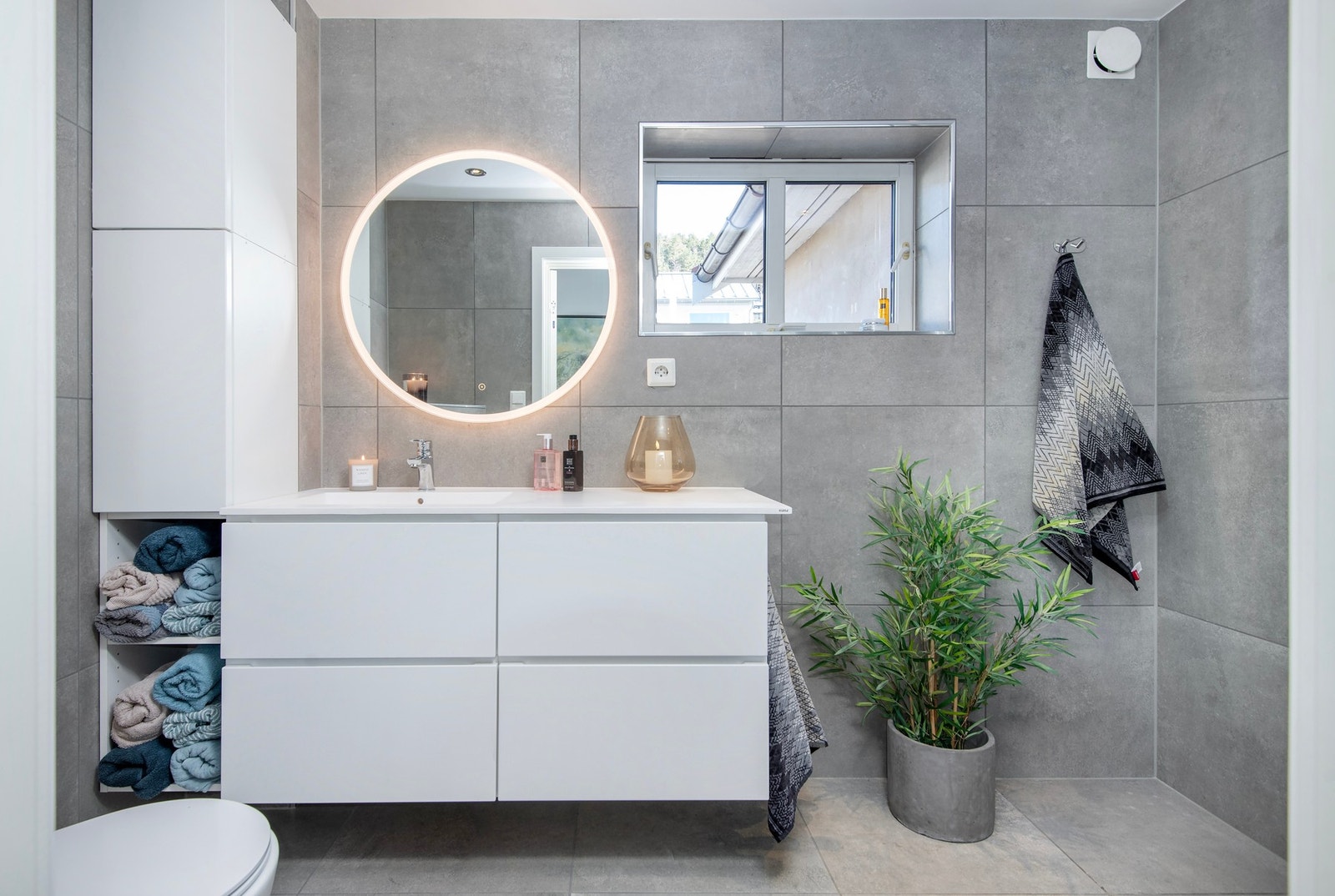 Lekkert helfliset velvære bad fra 2023 med elektriske varmekabler. Innredet med servantinnredning fra Kvik med helstøpt kompositt servantplate, høyskap, speil med integrert belysning - Galleribilde