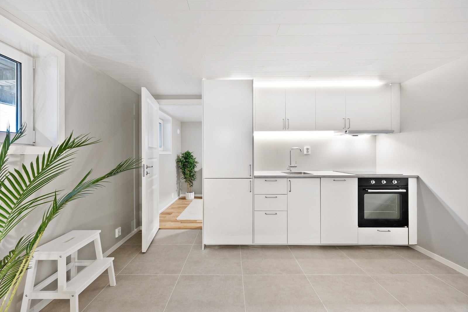 Kjøkkeninnredningen fra Ikea (2023) har hvite, glatte fronter og laminat benkeplate. Galleribilde