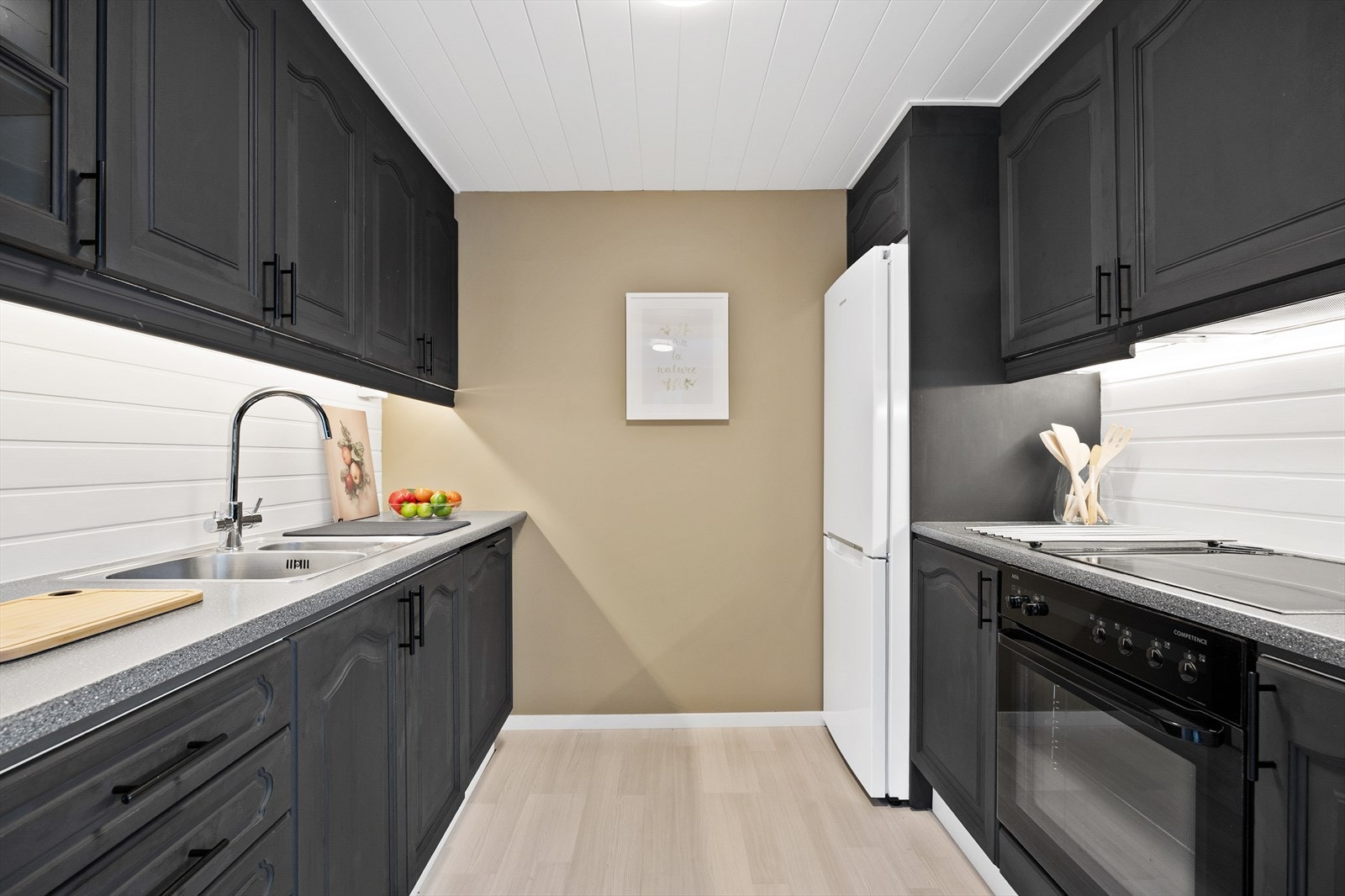 Kjøkken i åpen løsning med stue og med praktisk utforming. Galleribilde