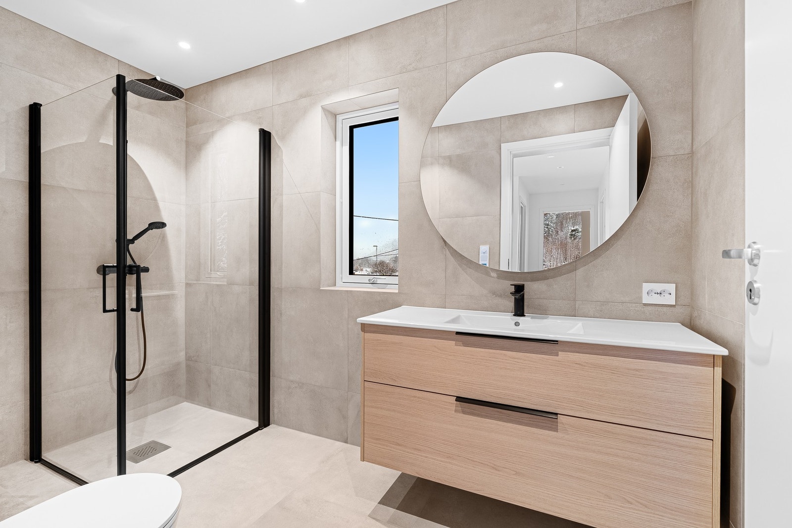 Flott flislagt bad med sorte detaljer. Galleribilde