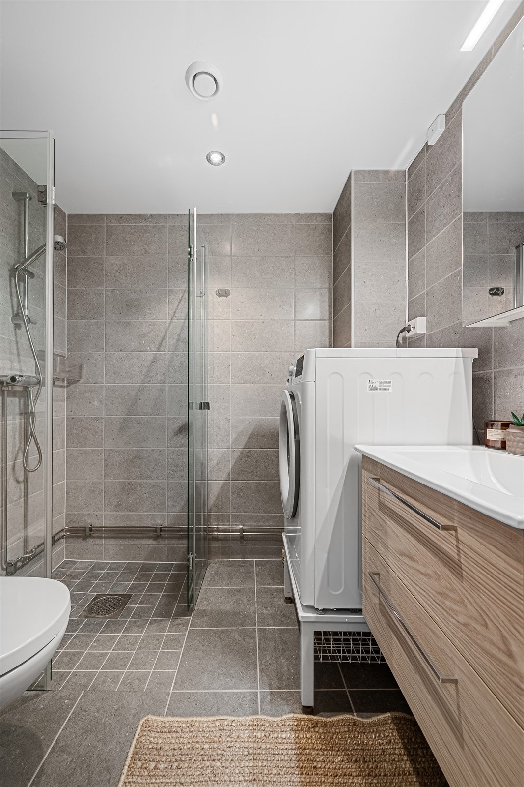 Badet er renovert i borettslagets regi -dusjhjørne, vegghengt toalett, servant og skap Galleribilde