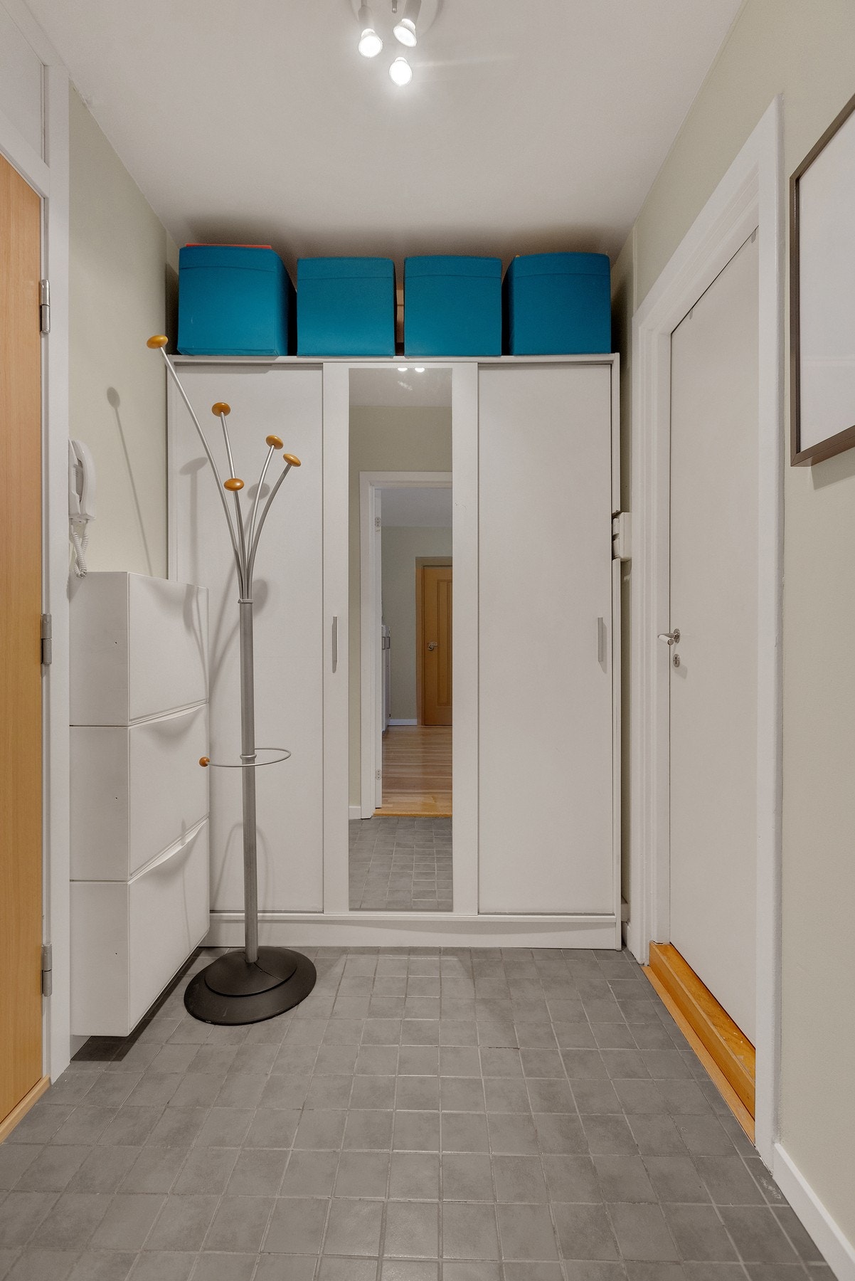 En fin entré med plass til ytterklær og dørcalling på veggen ved inngangsdøren Galleribilde