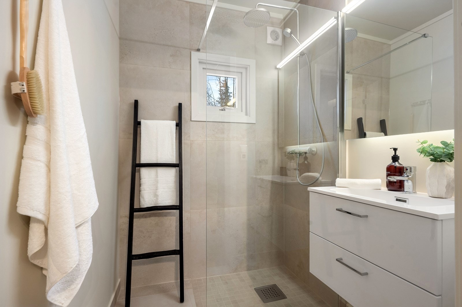 Lekkert bad fra 2025. Badet er flislagt med lyse fliser og innredet med servantinnredning med skuffer under samt dusj med fast dusjvegg. Galleribilde