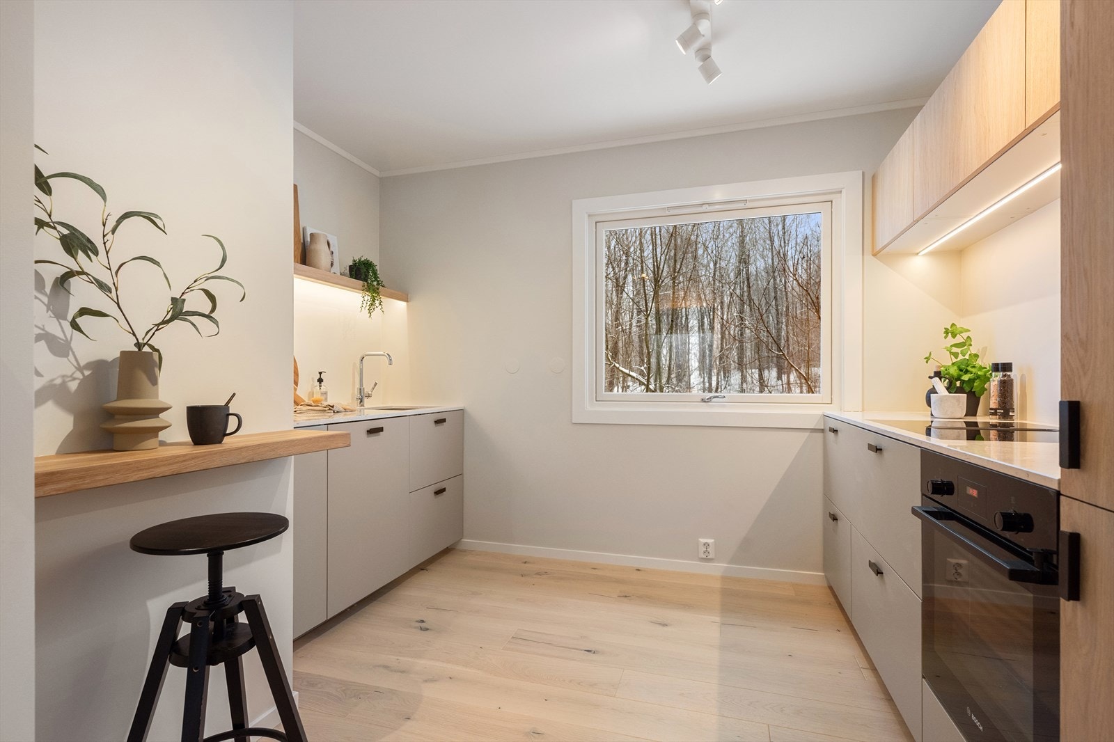 Romslig kjøkken også fra 2025. Her er det valgt grå fronter på underskap og møbelsnekrede eikefronter på overskap. Galleribilde