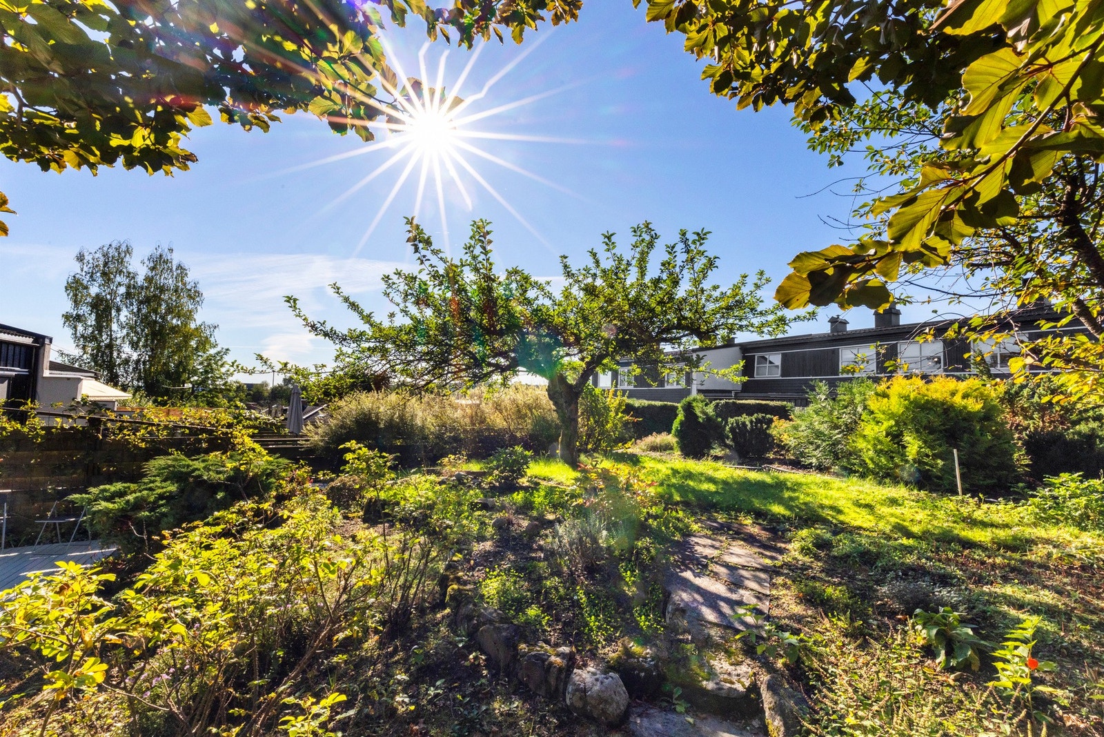 Tomten er pent opparbeidet med frukttrær, bærbusker, blomsterbed og gode dyrkingsmuligheter. Galleribilde