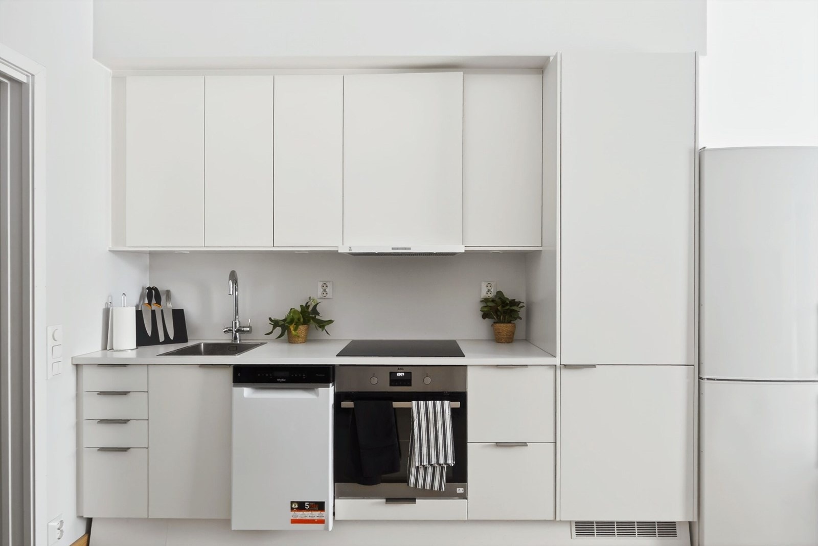 Stilrent kjøkken med glatte fronter - integrert induksjonstopp og stekeovn for et helhetlig uttrykk. Galleribilde