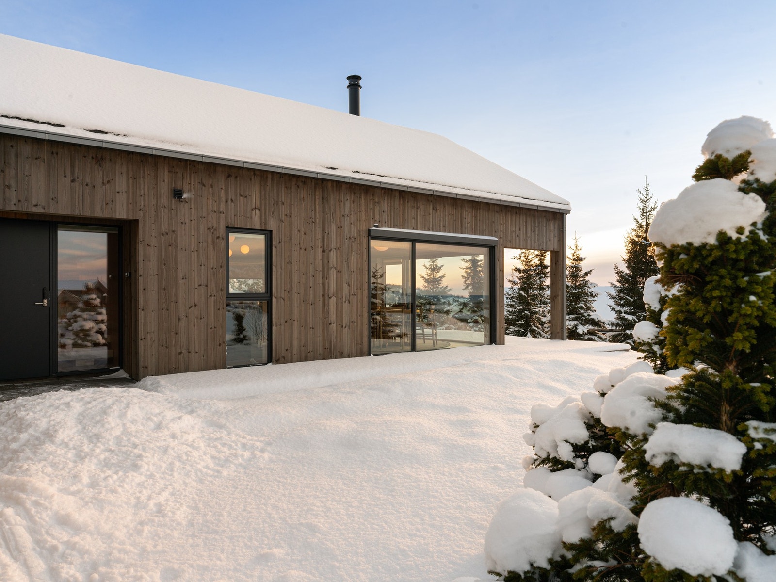 Moderne arkitektur med store vindusflater som gir innslipp av mye dagslys. Hytta ligger skjermet til med lite innsyn. Galleribilde