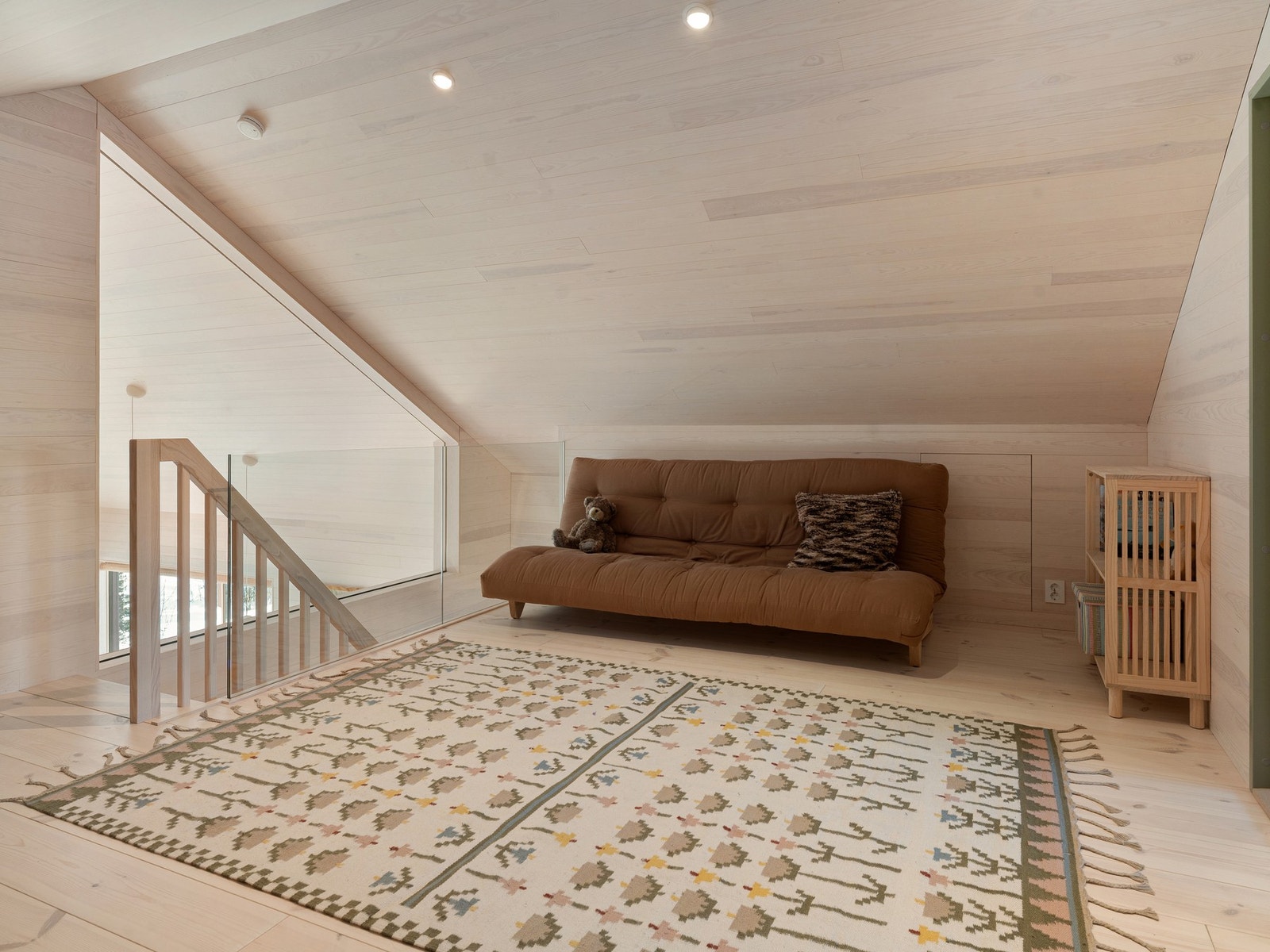 Stue i 2. etasje i hytta. Glassfelt med utsyn ned mot hoved-stua i 1. etasje. Galleribilde