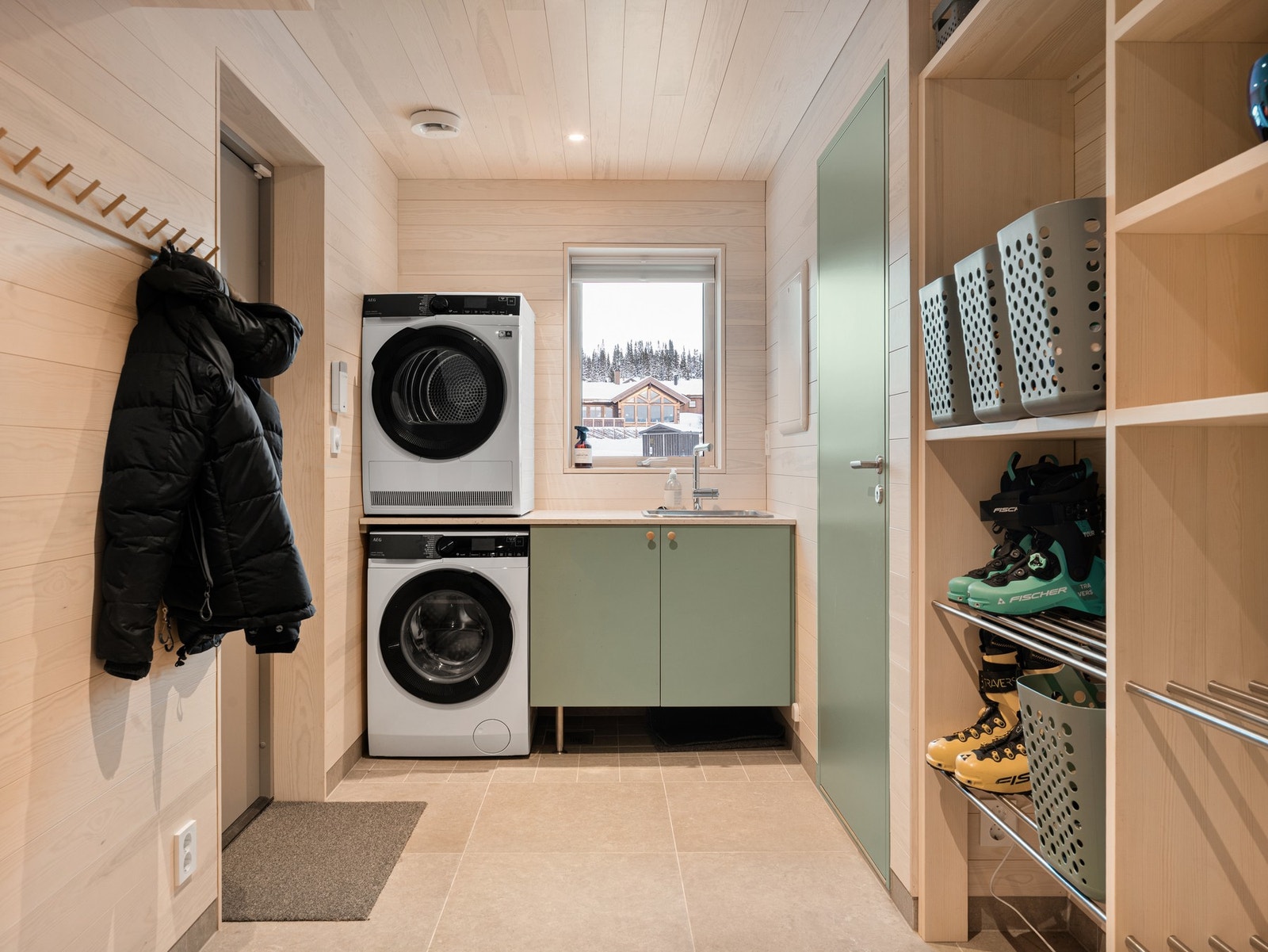 Vaskerom/bod med egen inngangsdør. En perfekt grovinngang når du kommer hjem etter ski- sykkel- eller løpetur. Dør inn til badet på høyreside. Galleribilde