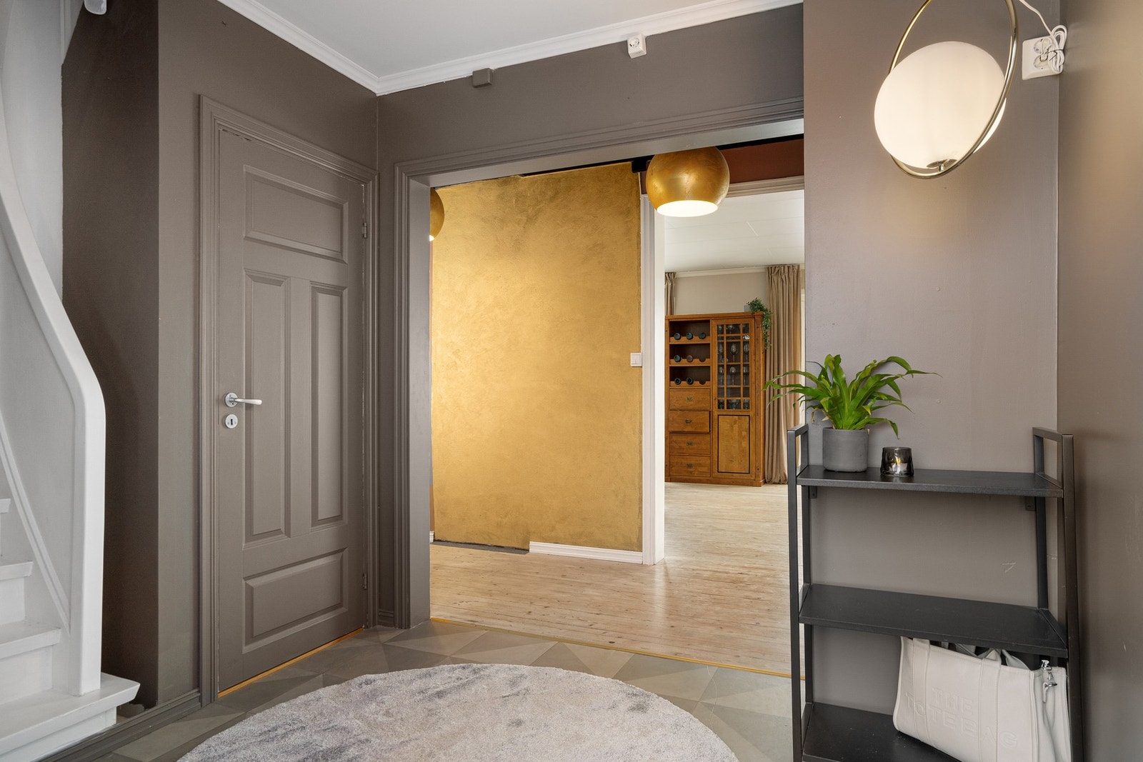 Romslig hall i første etasje med trapp til både kjeller og andre etasje Galleribilde