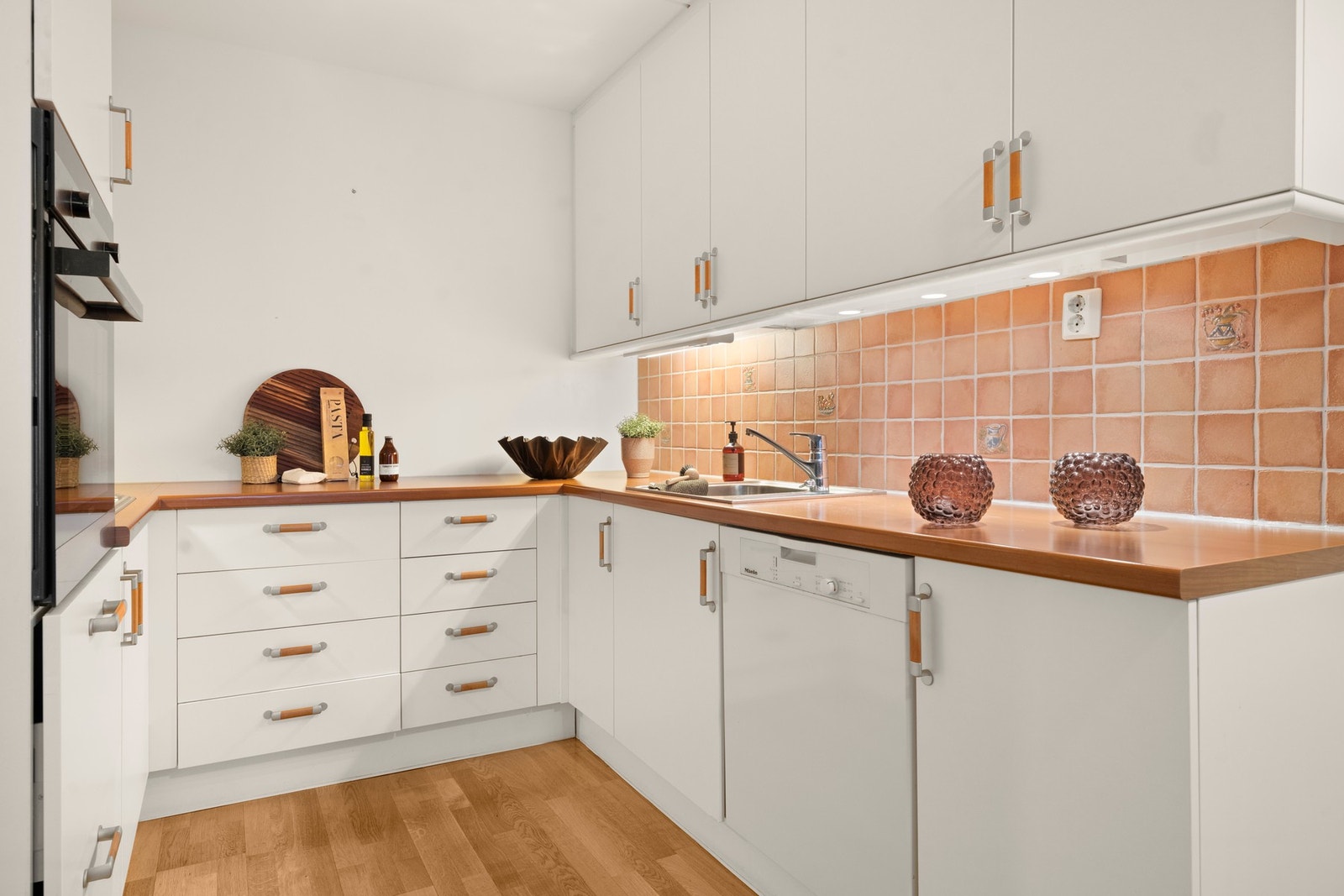 Utformingen gir rikelig med både benkeplass og lagringsplass, og kjøkkenet ligger i direkte tilknytning til stuen, en sosial åpen romløsning. Galleribilde