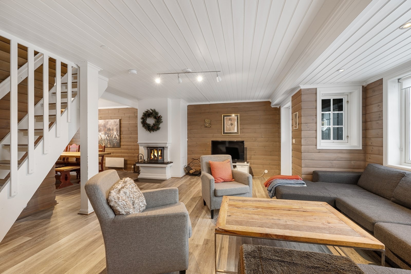 Stuen er hyttas samlingspunkt, med en sentralt plassert peis som gir god varme. Galleribilde