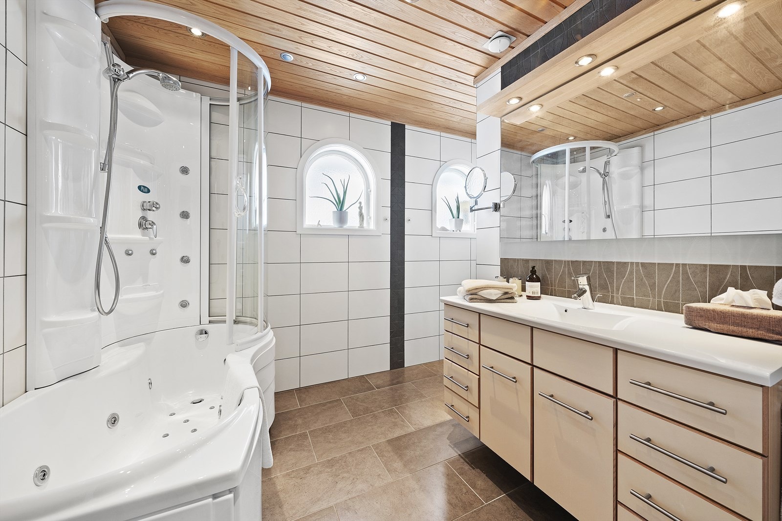 Badet i hovedetasjen er flislagt og er innredet med kombinasjon av dusjkabinett og badekar, en praktisk løsning som gir både effektiv hverdagskomfort og mulighet for et avslappende bad. Galleribilde