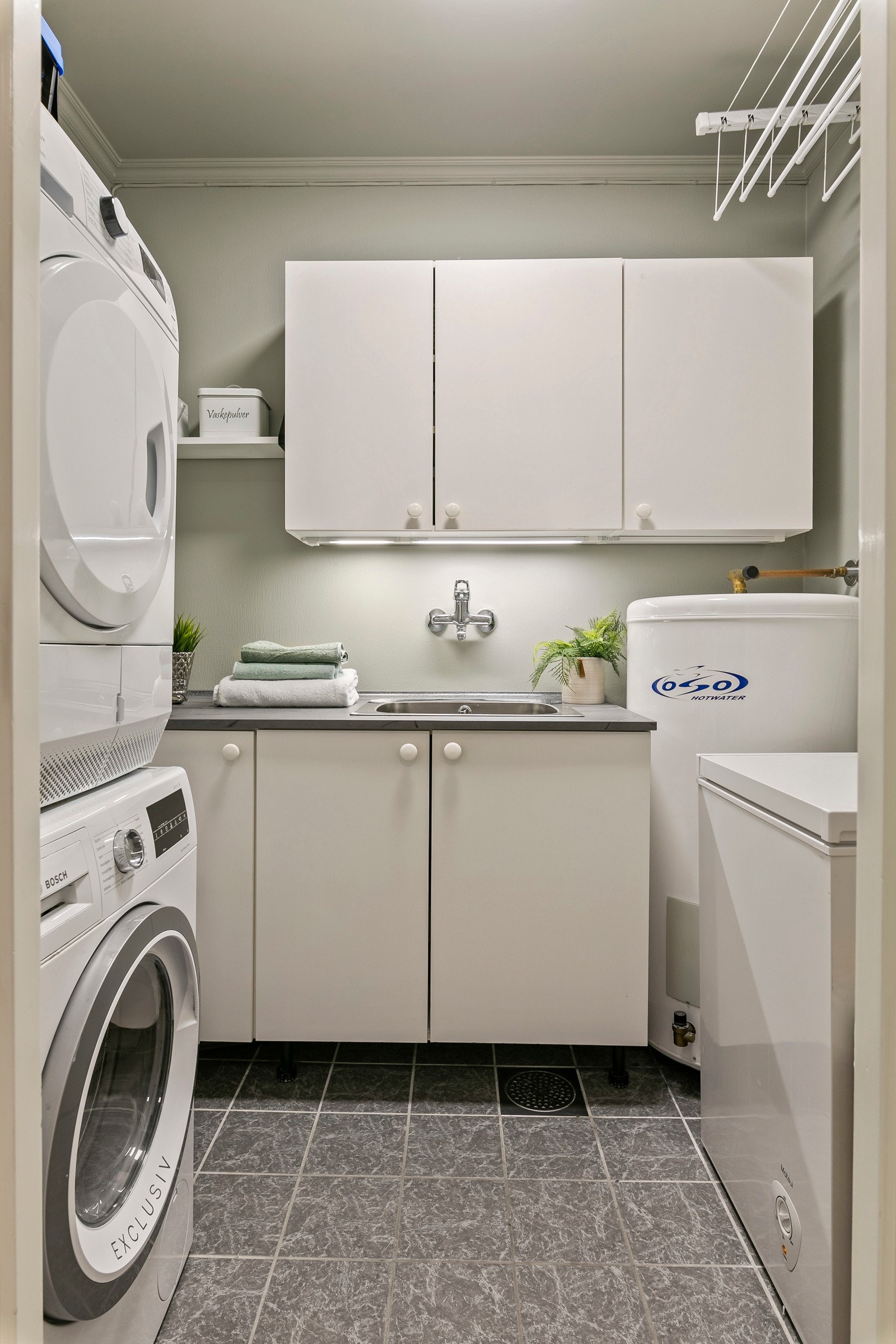 Leiligheten har også et eget, praktisk vaskerom med god lagringsplass Galleribilde