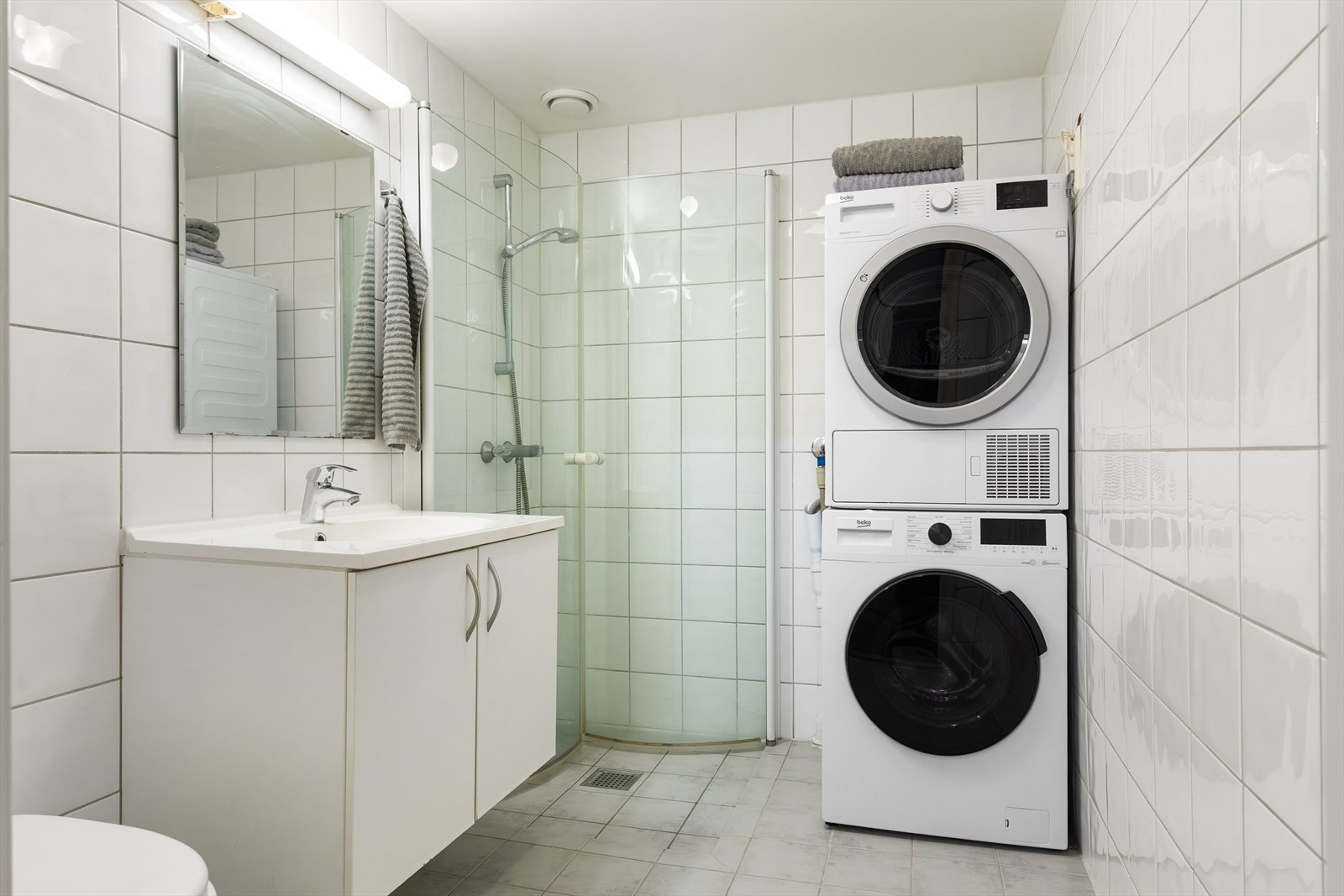 Romslig, flislagt baderom med fliser på vegger og gulv, samt malt himling. Galleribilde