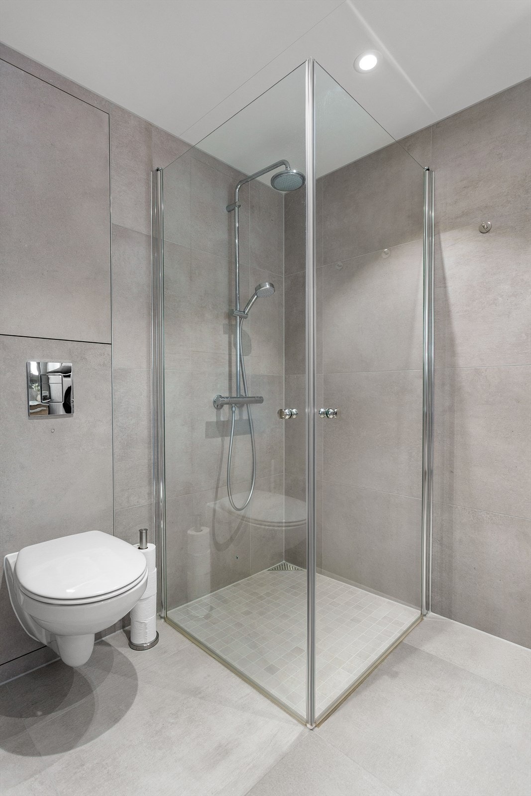 Badet har dusjhjørne med foldedører av glass og regnfallsdusj (nyere dusjarmatur) Galleribilde