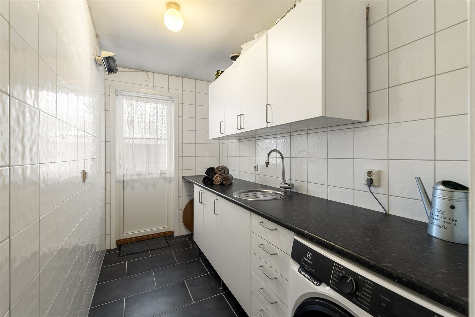 Vaskerommet er et funksjonelt og praktisk rom med egen inngang fra terrassen ved inngangspartiet. Her er det romslig vaskebenk med under- og overskap som gir gode lagringsmuligheter, samt opplegg for vaskemaskin og strømuttak for tørketrommel. Galleribilde
