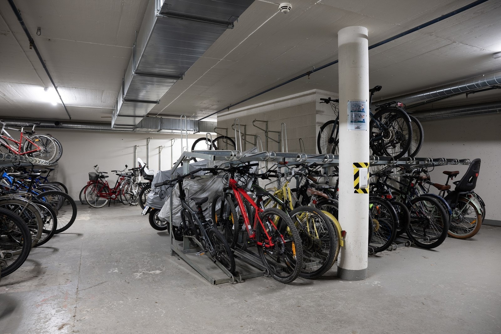 Stor felles sykkelparkering i garasjeanlegg. Galleribilde