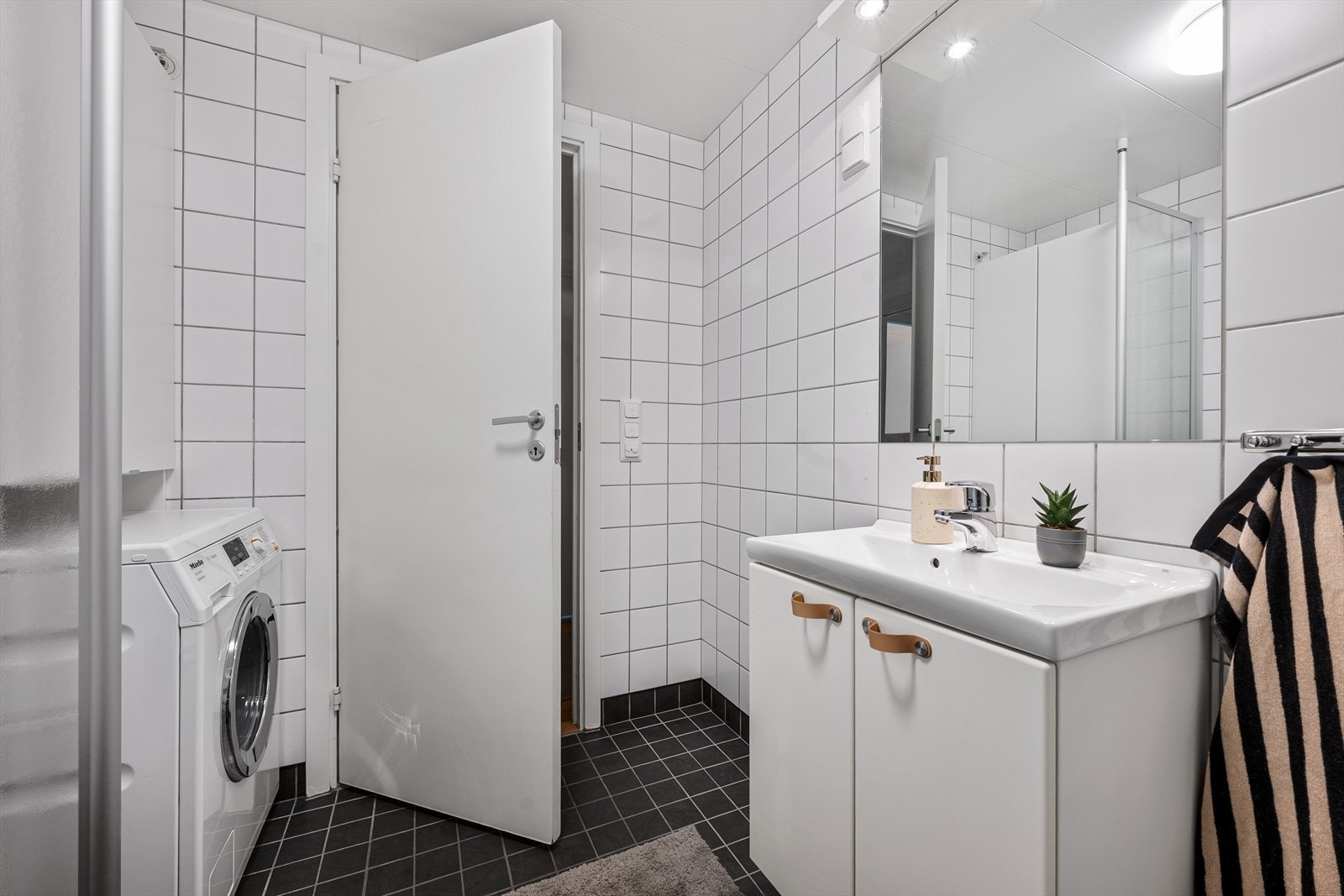 Pent, romslig og moderne flislagt bad med gulvvarme og opplegg for vaskemaskin. Galleribilde