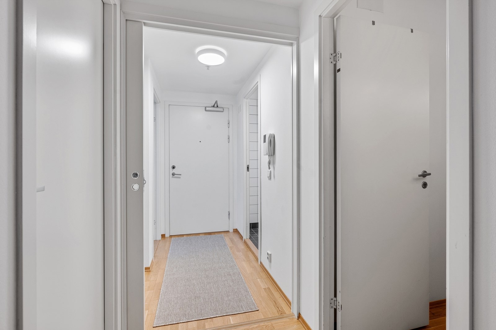 Lys og trivelig entré som gir et godt førsteinntrykk av boligen. Praktisk skyvedør for å skjerme samt lage soner i rommene. Galleribilde