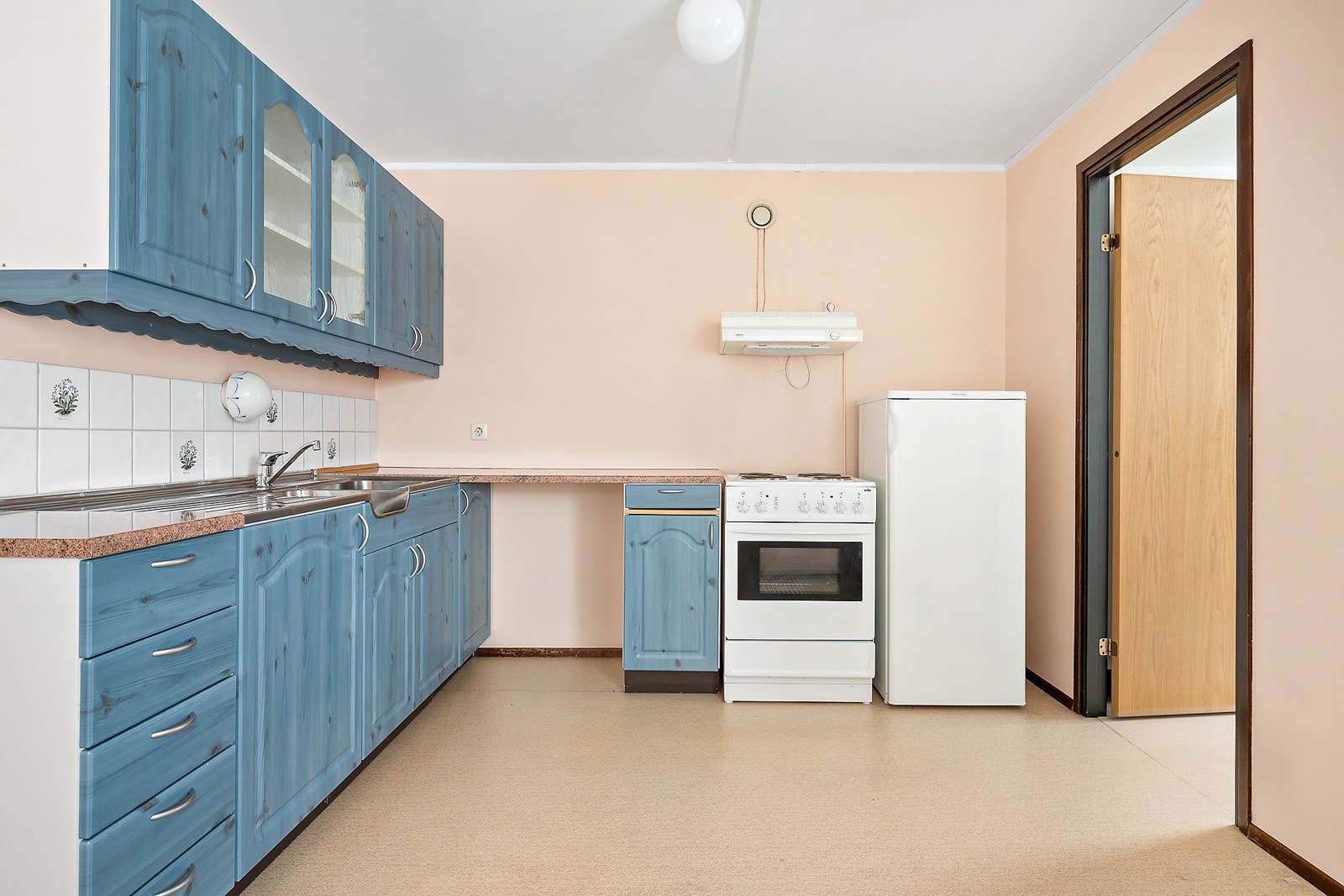 Kjøkkenet har plass til en spiseplass om ønskelig. Det er godt med skap- og benkeplass og det er frittstående hvitevarer som komfyr og kjøleskap Galleribilde