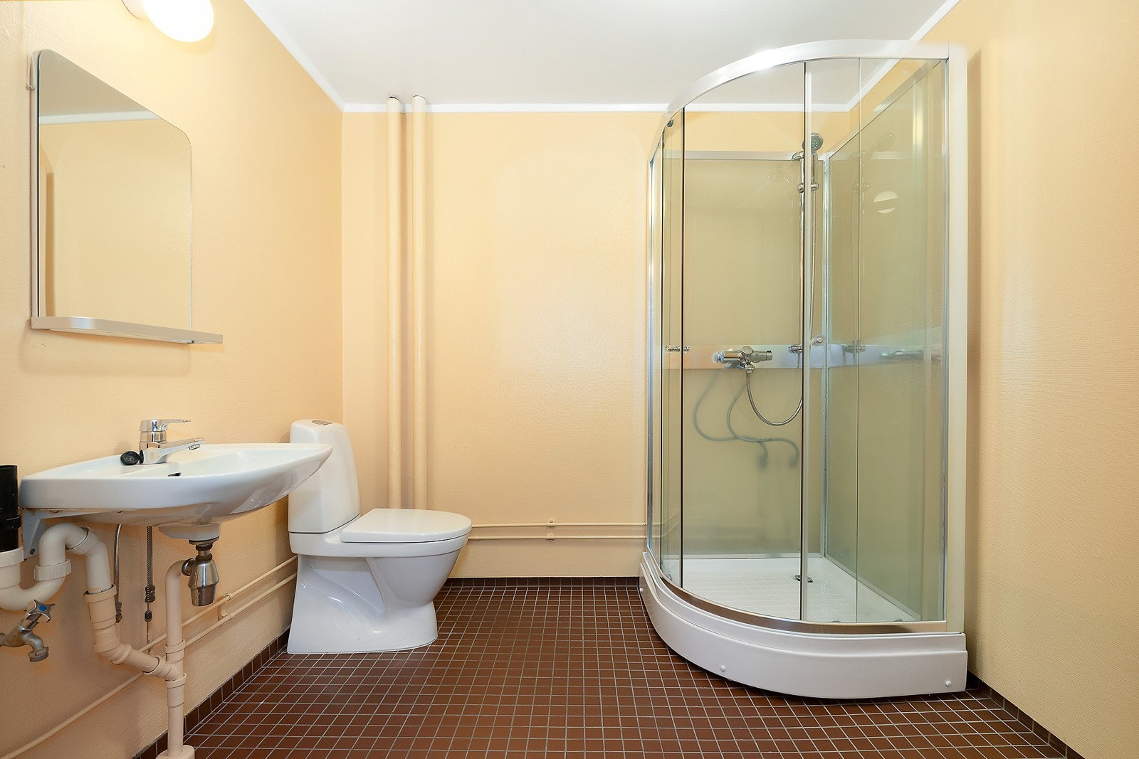 Badet er fra byggeår og har dusjkabinett, toalett, servant og opplegg for vaskemaskin Galleribilde